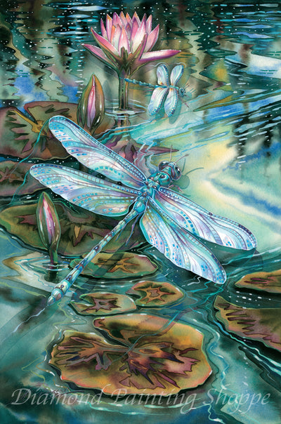 Watercolor-style diamond painting featuring two iridescent dragonflies hovering above lily pads and blooming pink water lilies on a shimmering pond.

